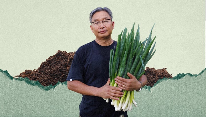 Un uomo di nome Youngsang Cho tiene in mano un mazzo di cipollotti. Si trova davanti a un mucchio di terra.